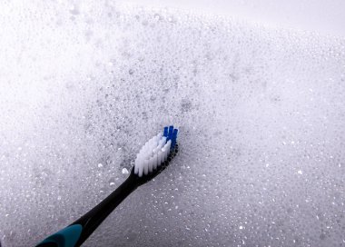 Diş fırçası akan su altında lavaboda temizlenir