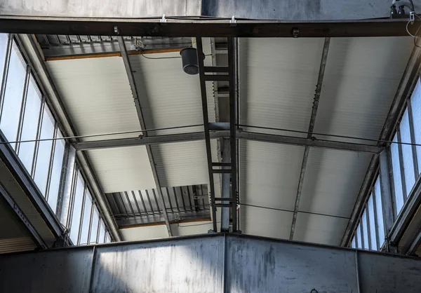 光の開口部と鉄の梁を持つ倉庫の天井 — ストック写真