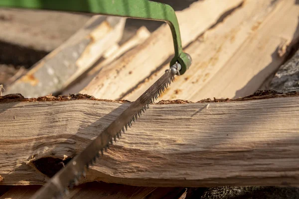 One-handed wood saw with coarse teeth saws a log of wood