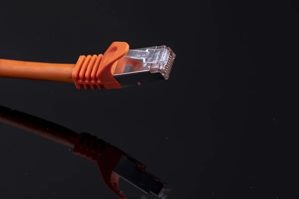 Cable de datos naranja para Internet rápido sobre fondo negro para una instalación doméstica moderna — Foto de Stock