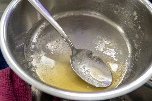 Срібна миска з розтопленим маслом і великою ложкою для випічки та приготування — стокове фото