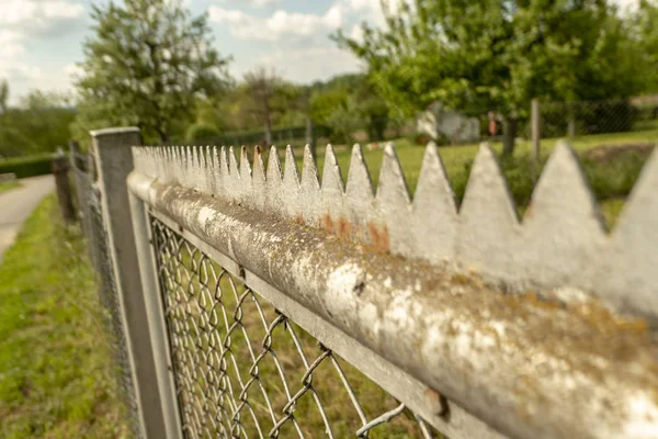 Stahlzaun mit spitzen Dornen zum Schutz auf einem Gartengrundstück — Stockfoto