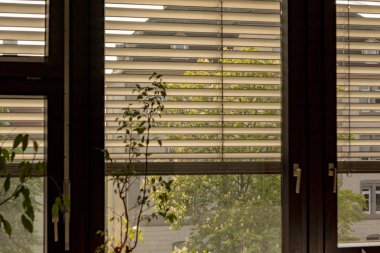 Gün batımında pencerede yarı alçaltılmış panjurlar