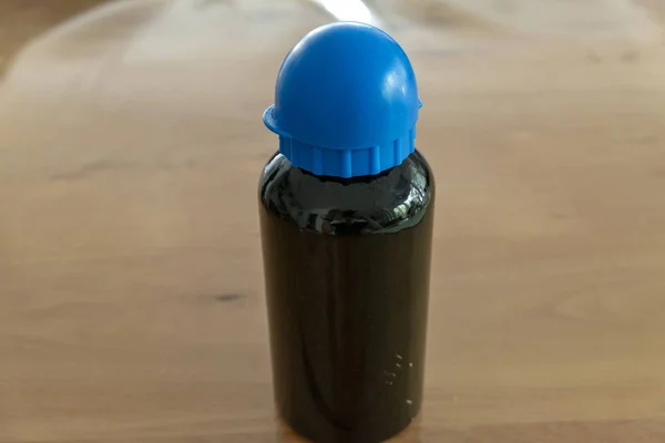 Пляшка для пиття з синьою шапочкою та чорною пляшкою з текстовим простором — стокове фото