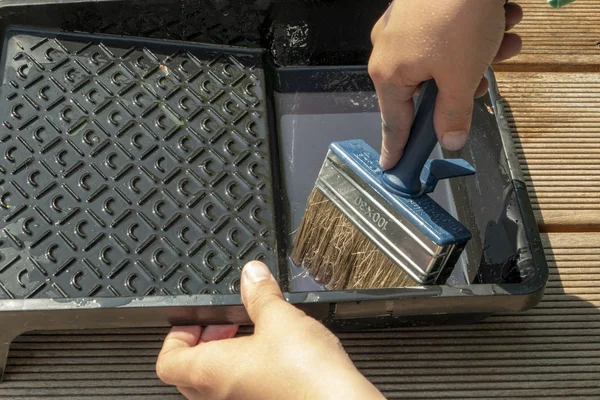 Hände mit großen Pinsel in Glasur tauchen, um die Terrasse zu malen — Stockfoto