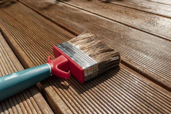 Brushes in the sun on the wooden terrace painted with glaze — Stock Photo, Image