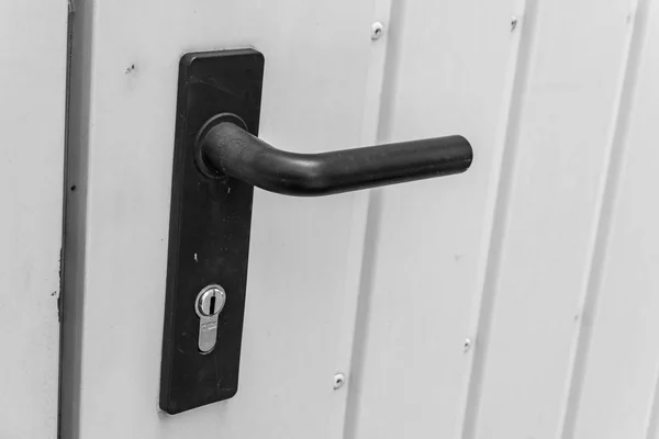 Manija de la puerta negra con cerradura en una puerta al garaje de chapa metálica — Foto de Stock