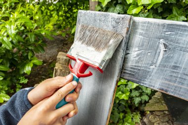 bir çocuğun elleriyle bir fırça ile ahşap boya