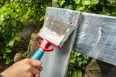 bir çocuğun elleriyle bir fırça ile ahşap boya