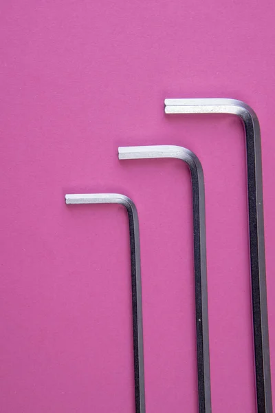 Три ключа, отсортированные по размеру на розовый — стоковое фото