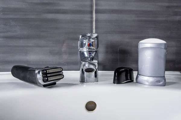 Afeitadora eléctrica con desodorante en el baño — Foto de Stock