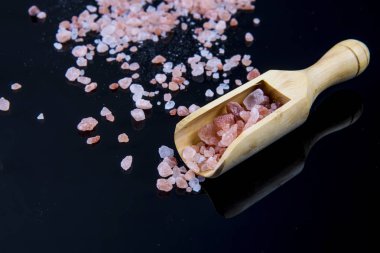 tahta kaşık ile siyah arka plan üzerinde tuz