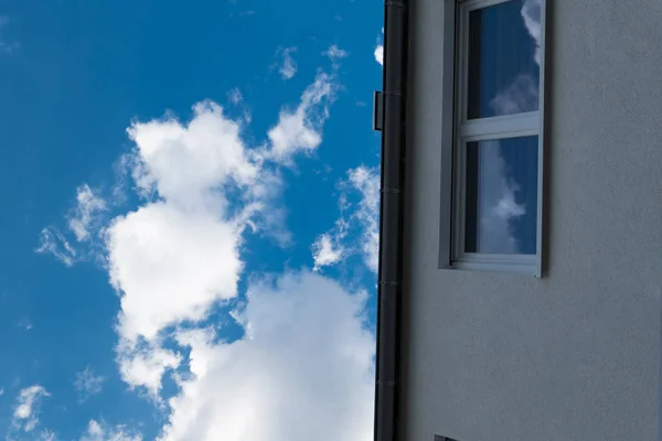 Modrá obloha s bílými mraky s domem a oknem — Stock fotografie