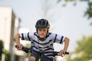 Bölgede bisikletiyle yarışan bisiklet kasklı çocuk
