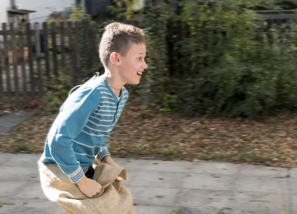 Garçon jouant course sac dans la rue à l'école — Photo