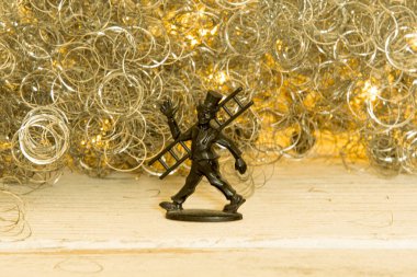 Baca siyaha boyanmış Noel arkaplanının önünde şans tılsımı gibi sallanıyor.