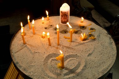 Mumlar kalpleriyle kumda yanıyor.