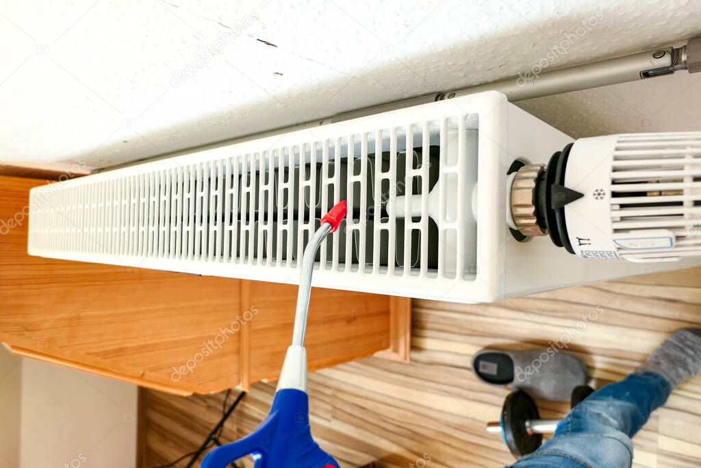 Clean dust from radiators in the room with compressed air