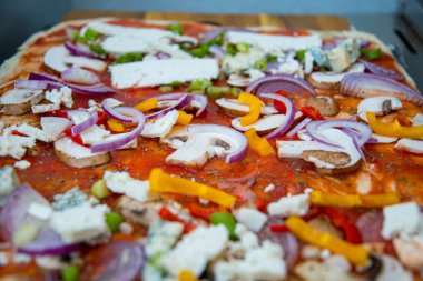 Sebzeli, soğanlı ve domates soslu pizza.