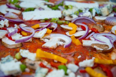 Sebzeli, soğanlı ve domates soslu pizza.