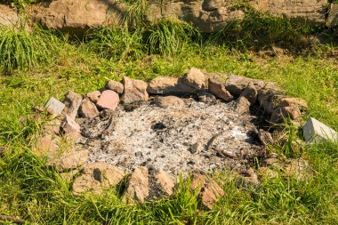 Çayırda külleri olan vahşi bir şömine.