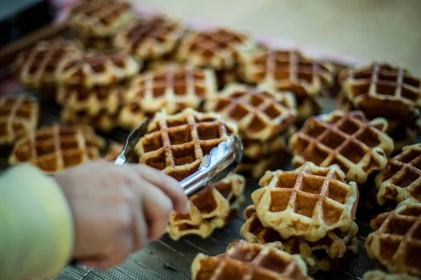 Mão Segurando Grande Waffle Tong Cozinha Com Mais Waffles Fundo — Fotografia de Stock