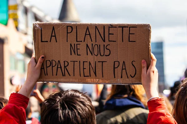 Экологический активист держит французский знак — стоковое фото