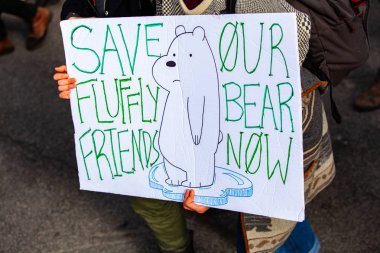 İklim savunucusu protesto işareti tutar