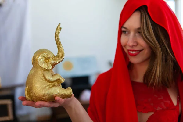 Nő tartja arany elefánt figura. — Stock Fotó