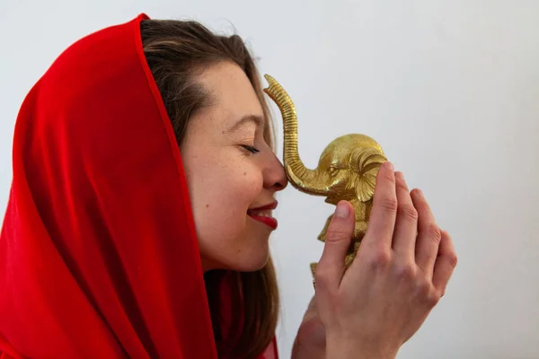 Nő tartja arany elefánt figura. — Stock Fotó