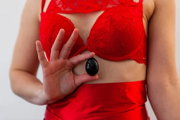 Mujer en lencería roja sostiene huevo de jade . —  Fotos de Stock