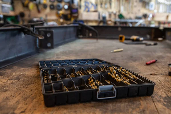 Metalwork drill bits in plastic tub