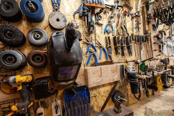 Metalwork tools hang on wall in workshop — Stock Photo, Image