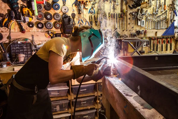 Tradesman operates MIG welder indoors — Stock Photo, Image