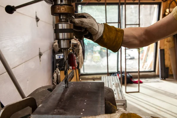 Metalworker utiliza taladro de banco en taller — Foto de Stock