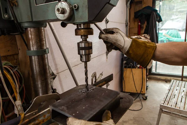 Herrero utiliza prensa de taladro en el garaje — Foto de Stock