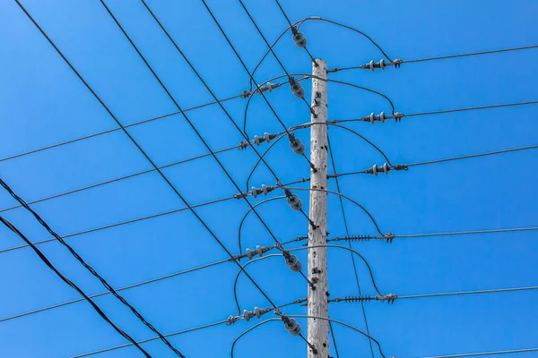 Elektřina se tyčí proti modré obloze. — Stock fotografie