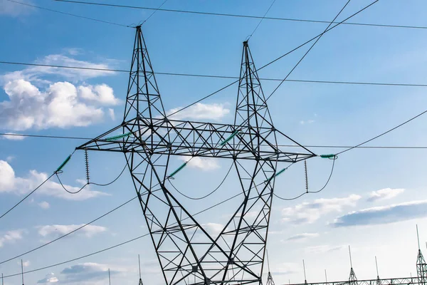 Electricity towers against a blue sky.