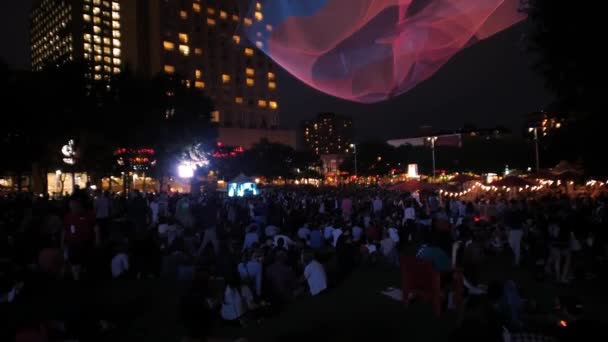 Gente paseando por el parque durante la noche — Vídeo de stock