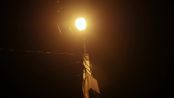 Farola con luz iluminada en la oscuridad — Vídeo de stock