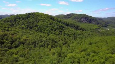 İnsansız hava aracı yeşil tepelerin üzerinde uçuyor