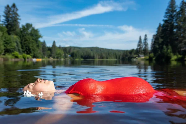 Pregnant woman floating in a lake — Stock Photo, Image