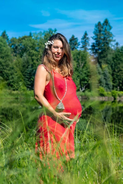 Gravid kvinna poserar i skogarna — Stockfoto