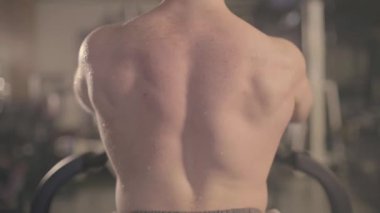 Spor salonunda spor yapan üstsüz erkek sporcu.