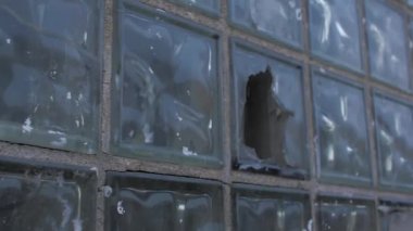 Duvarında grafiti olan kırık cam bir pencere.