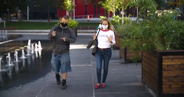 Couple en masque sur une promenade avoir la conversation — Video