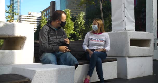 Couple sitting on bench with mask talking — Stock Video