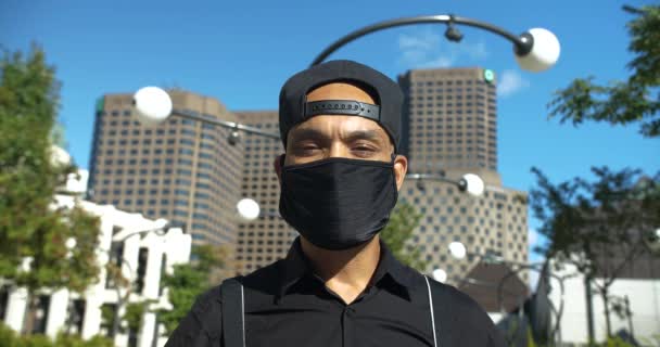 Чоловік в масці для обличчя і кепці, дивлячись вгору — стокове відео