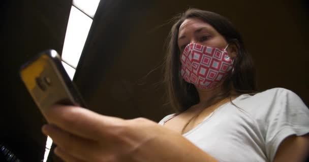 Mujer con máscara en metro subterráneo con teléfono — Vídeo de stock