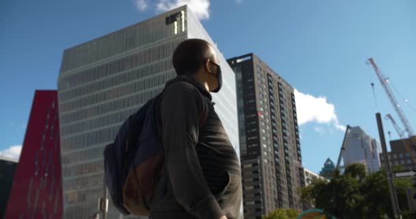 一个戴面具的年轻人在市中心走动 — 图库视频影像